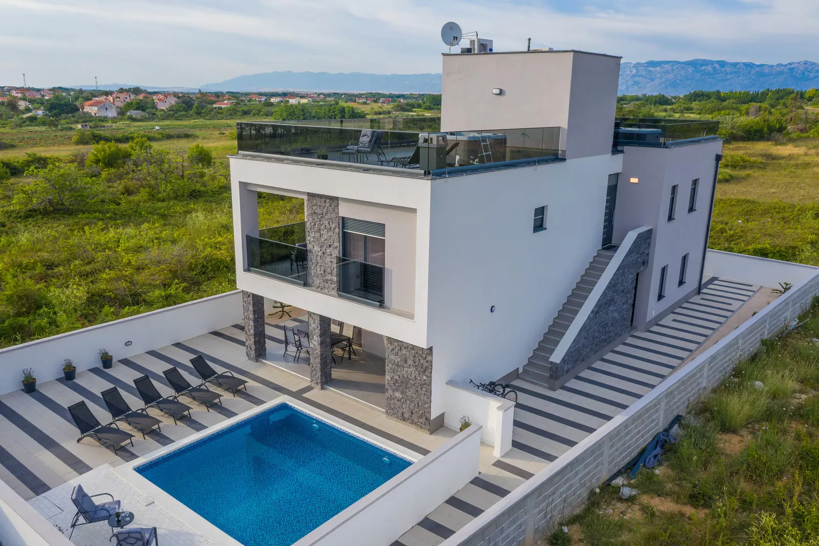 Aerial view of the villa and its pool above the coast